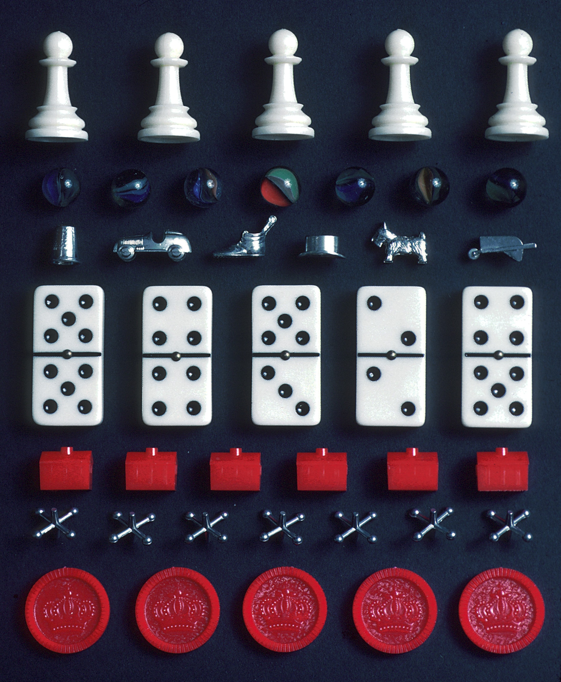 Public-domain photograph of assorted board-game pieces including chess pawns, dominoes and marbles